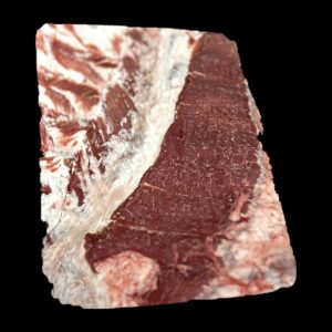 Pancetta di maiale fresca su fondo nero, con gli strati alternati di magro e grasso