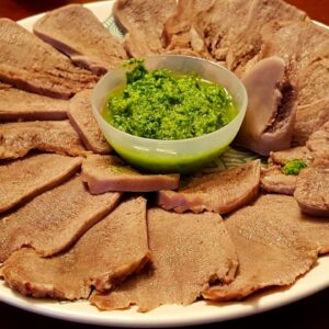Lingua di vitellone lessata e affettata, servita con salsa verde
